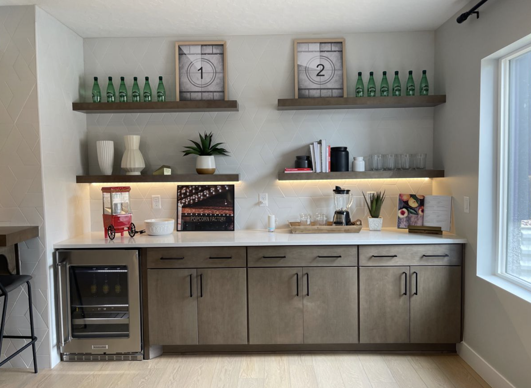 مطبخ أنيق مع سناك بار مرتب عليه حلويات ومعجنات وصحون تقديم بإضاءة دافئة