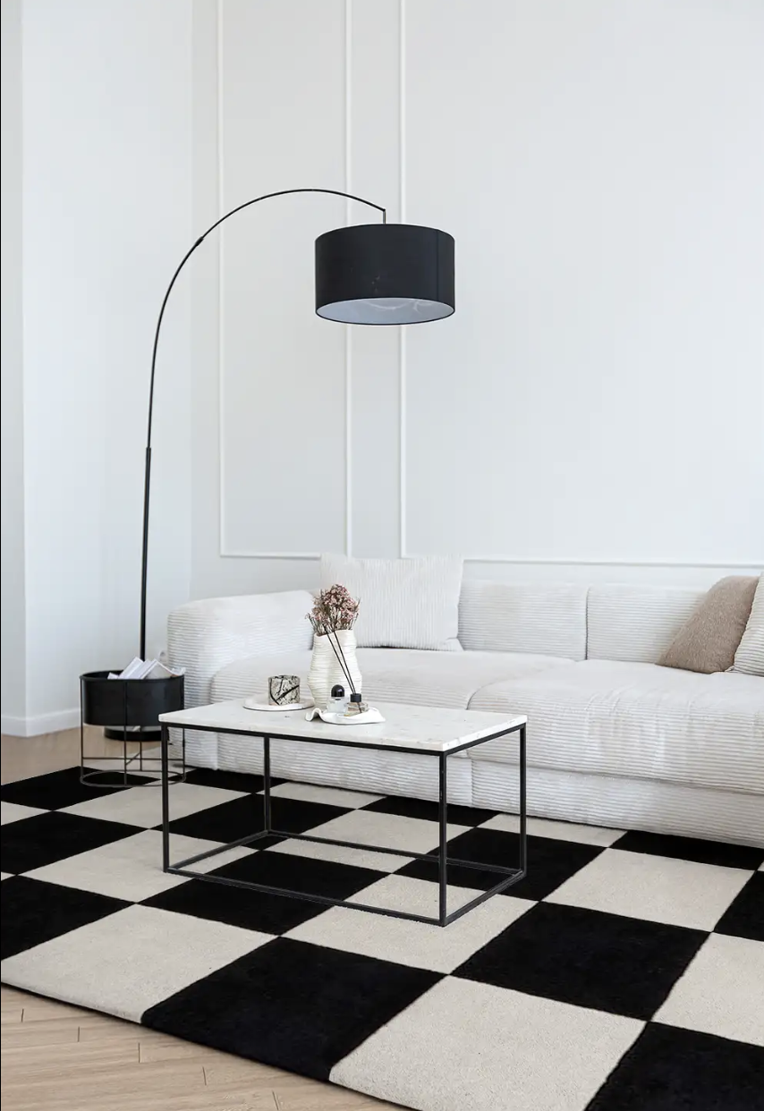 سجادة بنقش مربعات كبيرة بالأسود والأوف وايت في غرفة معيشة حديثة بكنبة فاتحة
