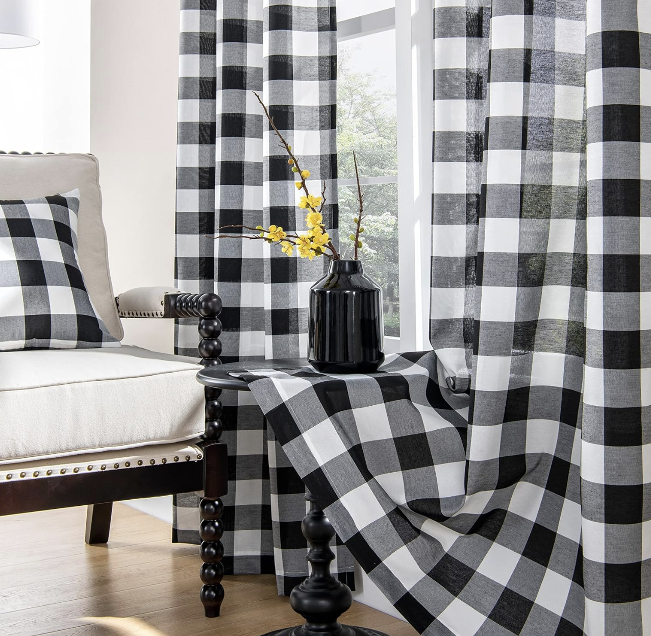 ستائر مربعات كبيرة بالأبيض والأسود بجانب نافذة مضيئة ولمسة ديكور بسيطة