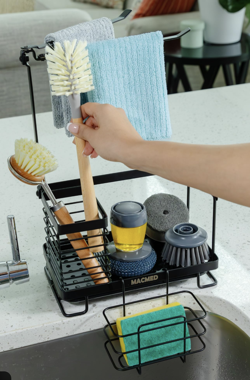 منظم أدوات تنظيف قرب الحوض مع فوط معلّقة وفرش تنظيف وسوائل، لتسهيل إعادة الضبط السريعة أثناء تجهيز الطعام.