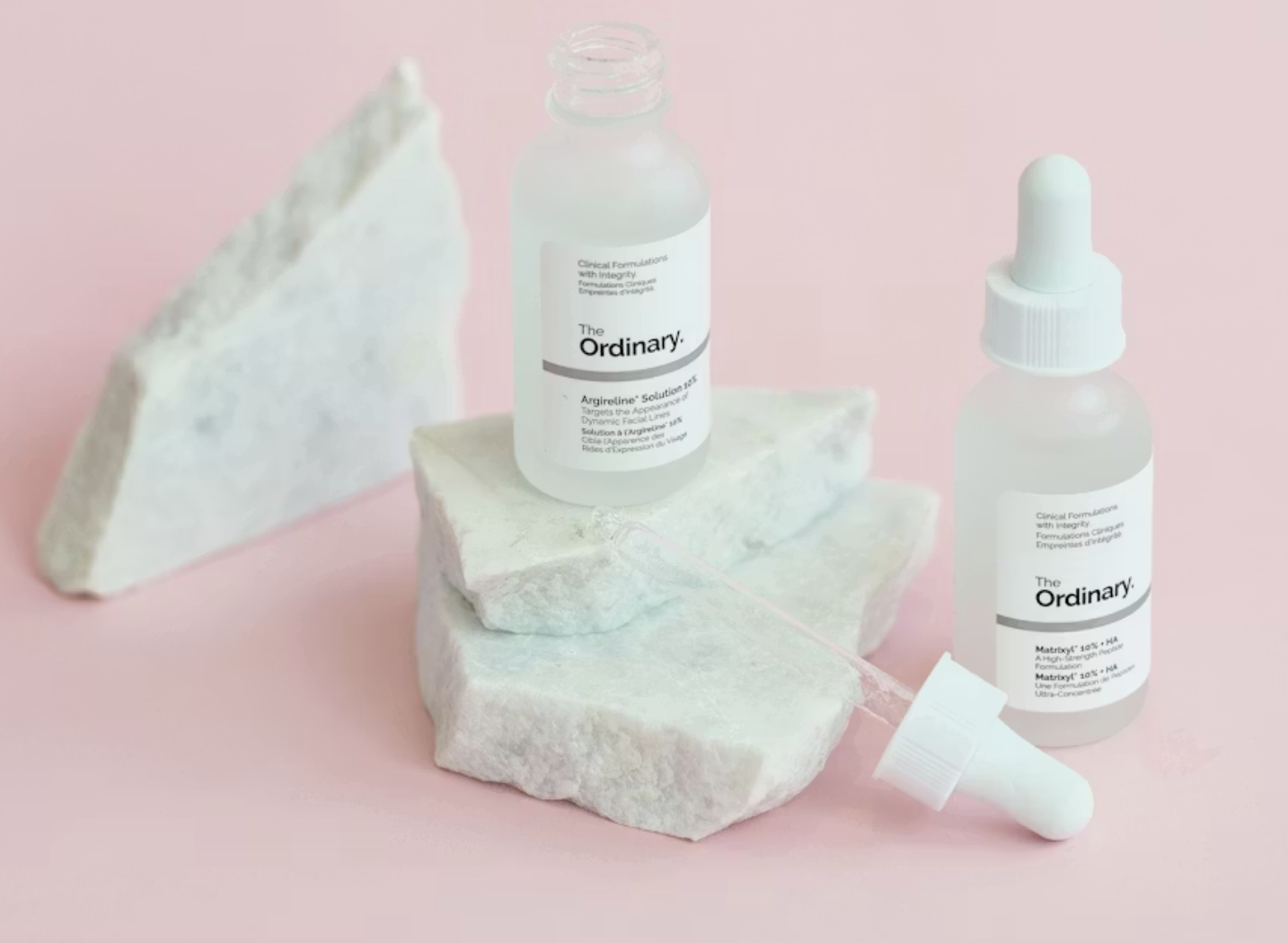 Hypochlorous Acid للبشرة مع منتجات عناية على رخام وخلفية فاتحة لتوضيح روتين تهدئة الاحمرار للبشرة الحساسة.