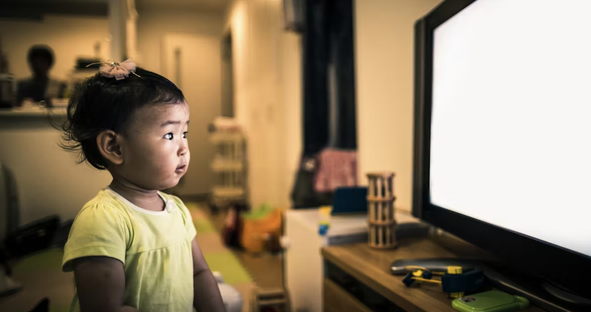 قصر النظر عند الأطفال بسبب الشاشات: طفل يجلس قريبًا جدًا من شاشة التلفاز—سلوك قد يشير لصعوبة رؤية الأشياء البعيدة.