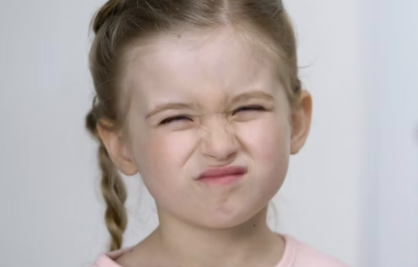 صر النظر عند الأطفال بسبب الشاشات: طفلة تُضيّق عينيها عند محاولة رؤية شيء بعيد كعلامة محتملة لصعوبة الرؤية للمسافات.